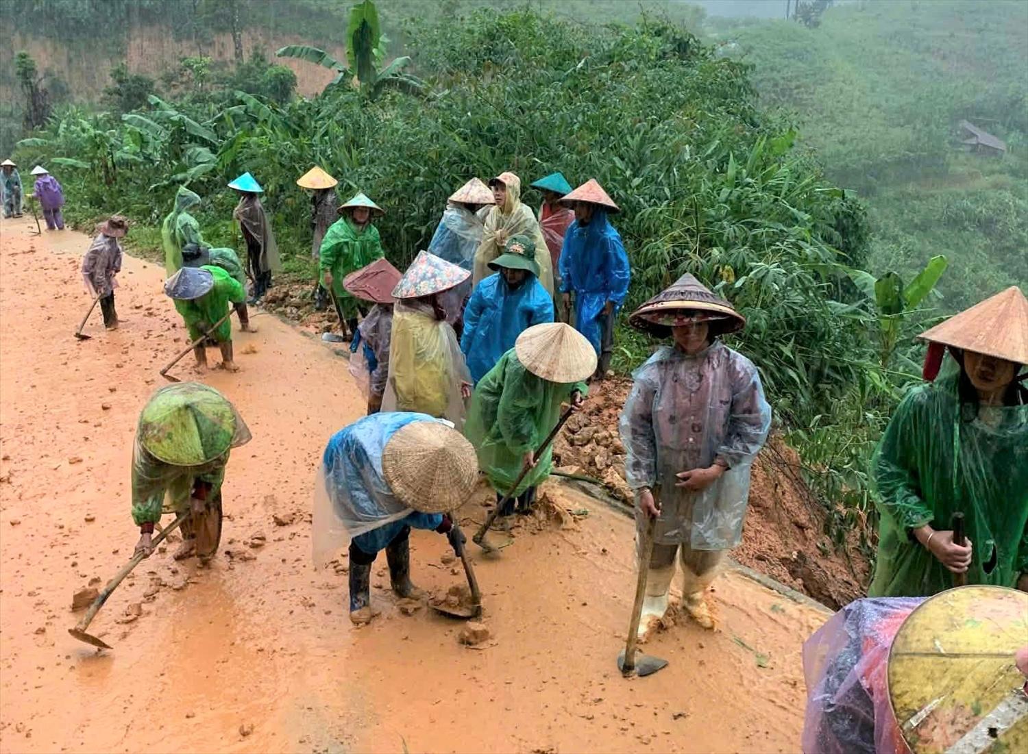 Phụ nữ và người lớn tuổi thì lo phần việc dọn dẹp bùn đất trên các tuyến đường. (Ảnh: Ngọc Chí)