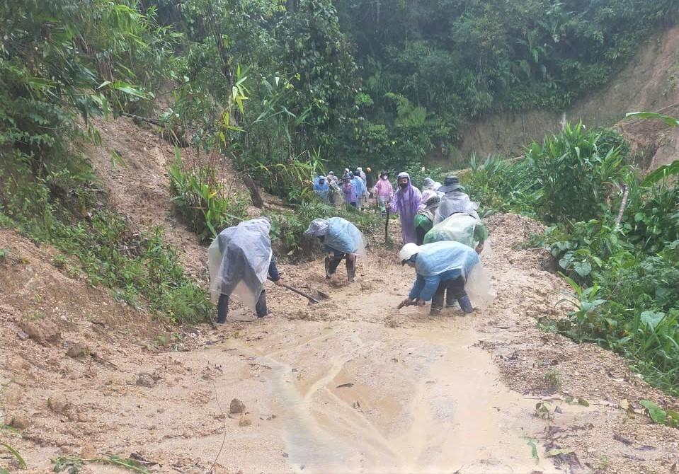 Người dân thôn Đăk Nai, xã Ngọc Linh tập trung khắc phục sạt lở trên tuyến đường dẫn lên thôn. (Ảnh: Ngọc Chí)